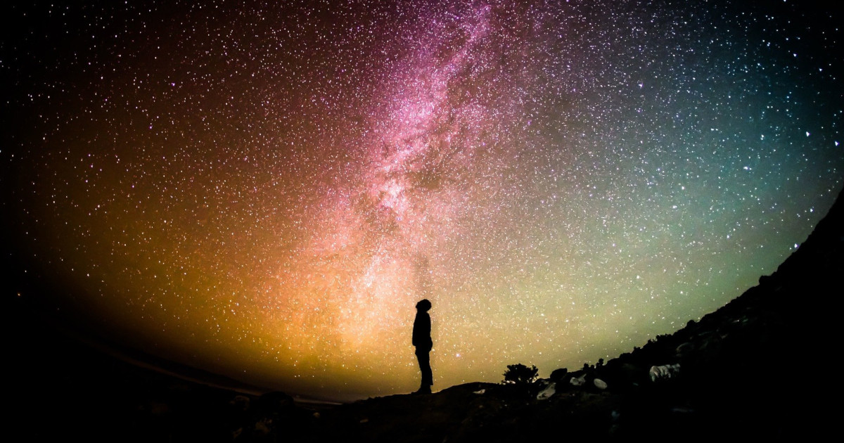 Silhouette of person looking up at Milky Way