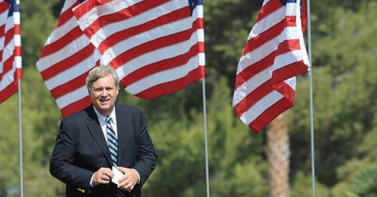 Tom Vilsack and some American flags.