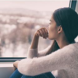 woman sitting beside a window looking out at the city skyline