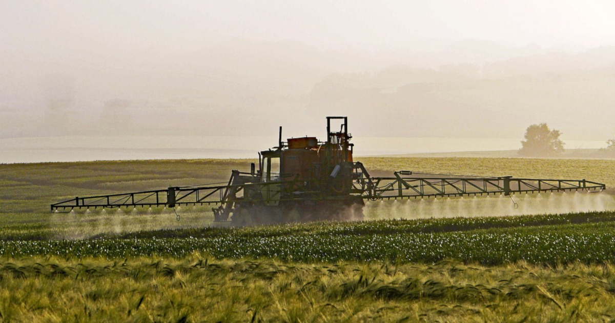 farm spraying pesticides on field